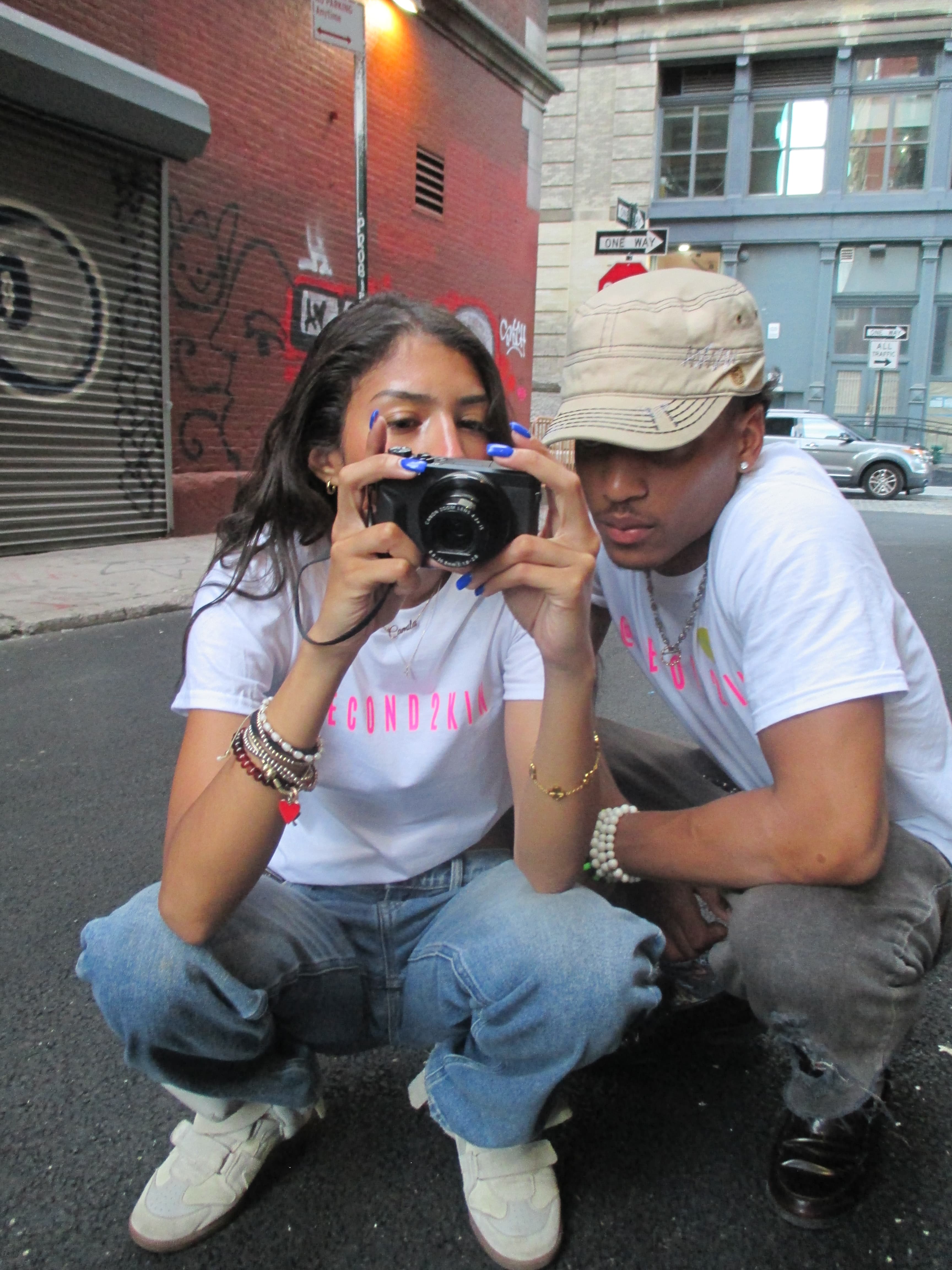 Two people in 2econd2kin tees looking at camera