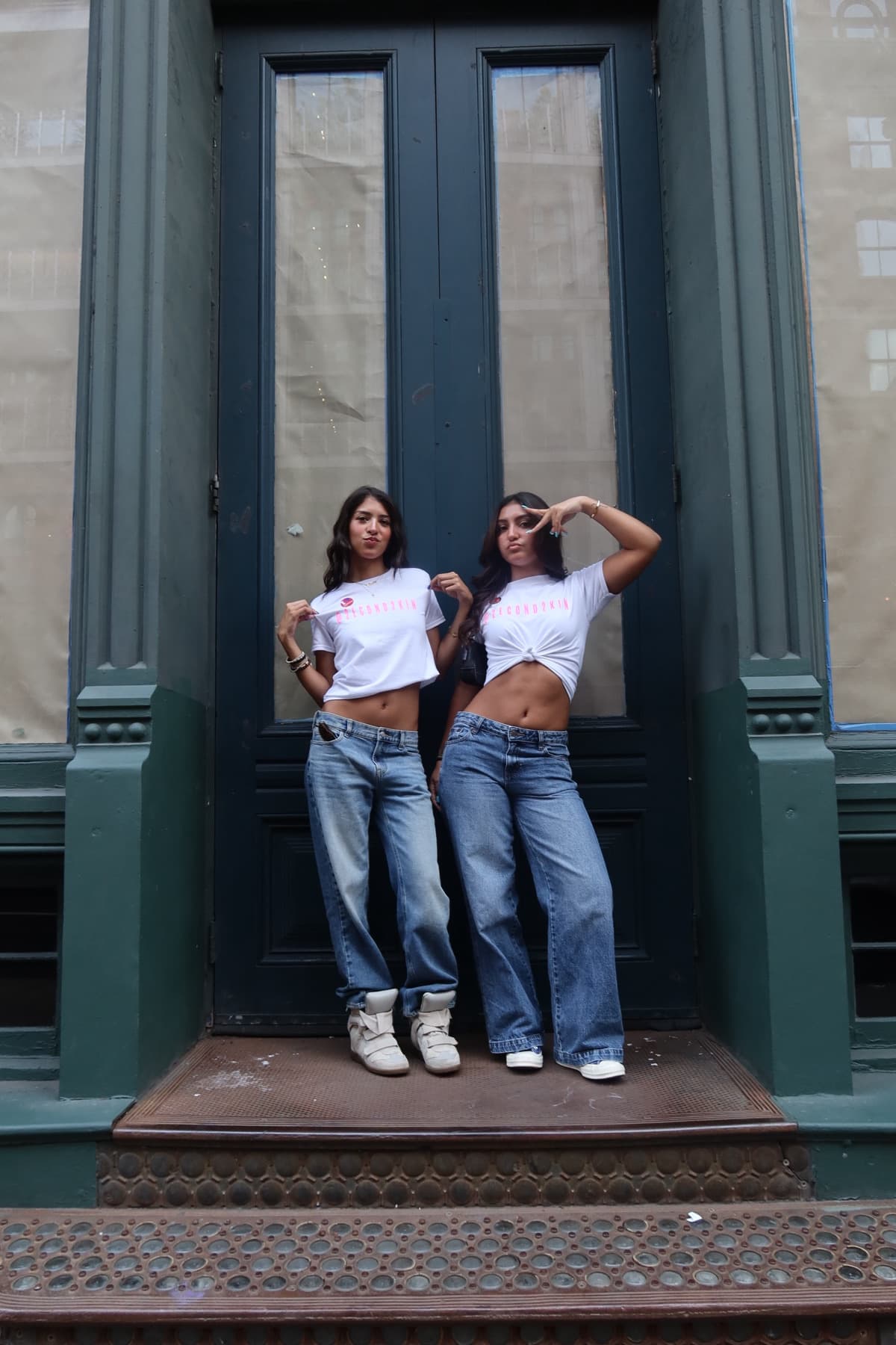 Two models in 2econd2kin Magazine tees posed in a brownstone doorway