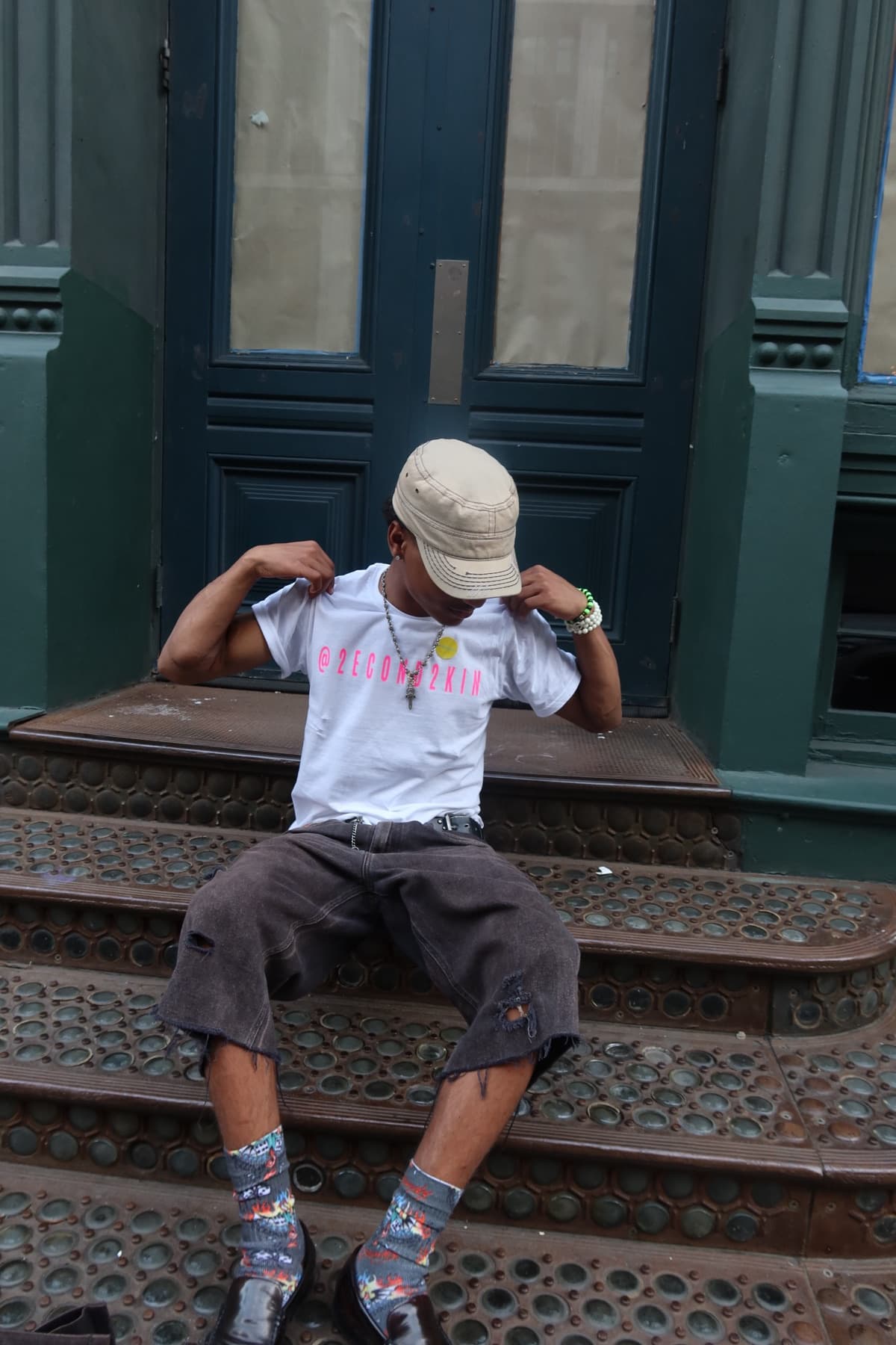 FaurY seated on brownstone steps, flexing