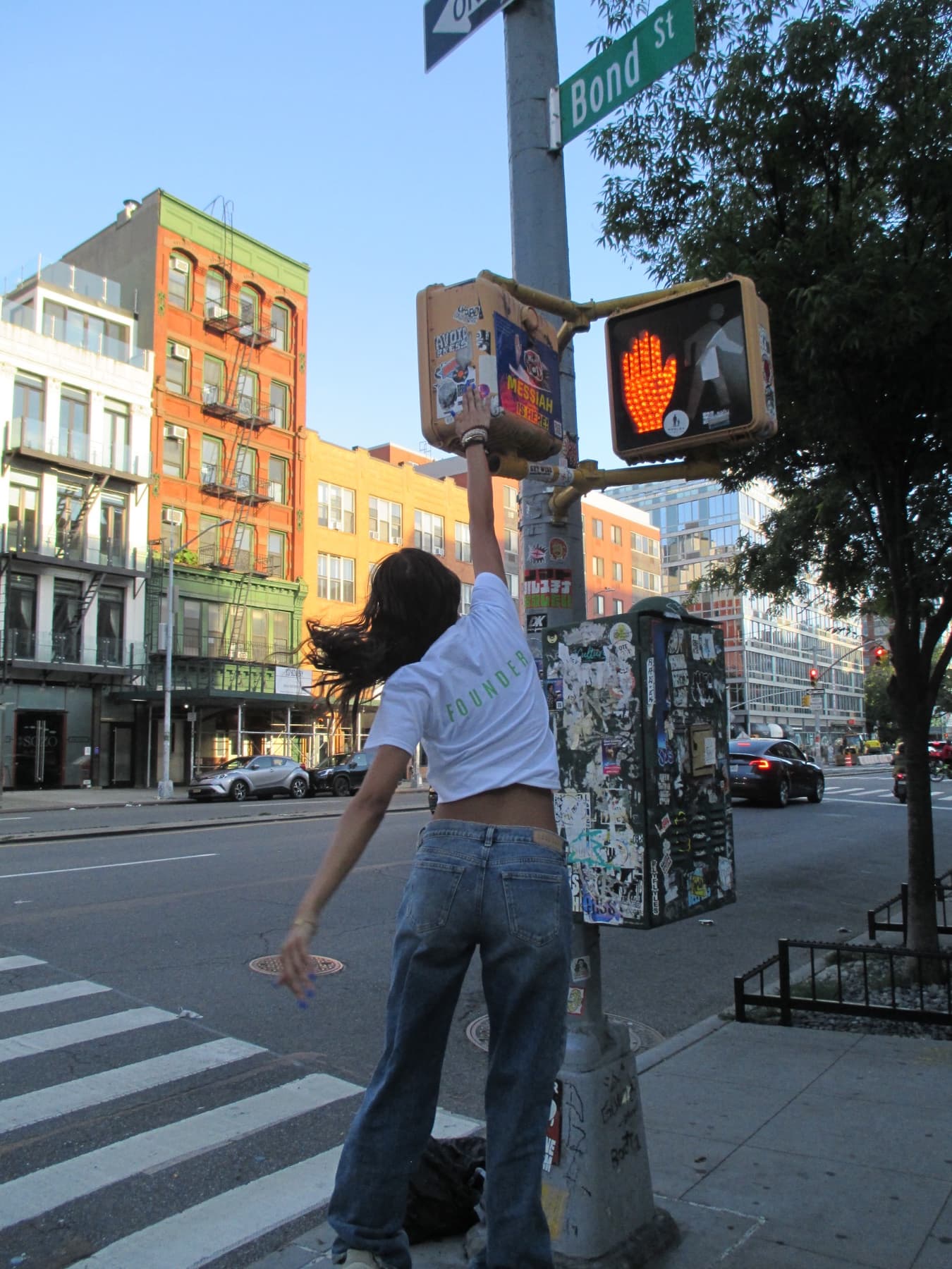 FaurY reaching up to a pedestrian crossing signal
