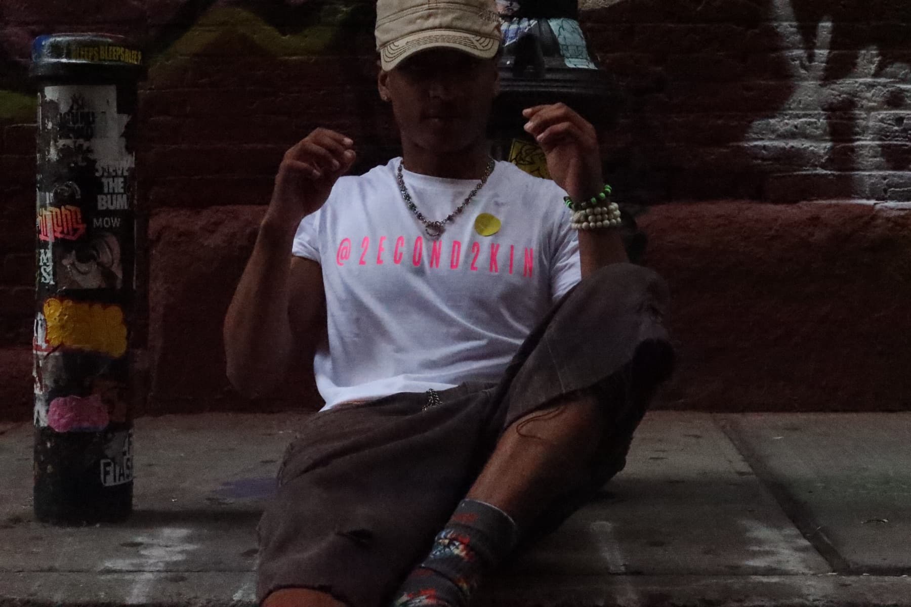 FaurY on a phone call, seated in an alley