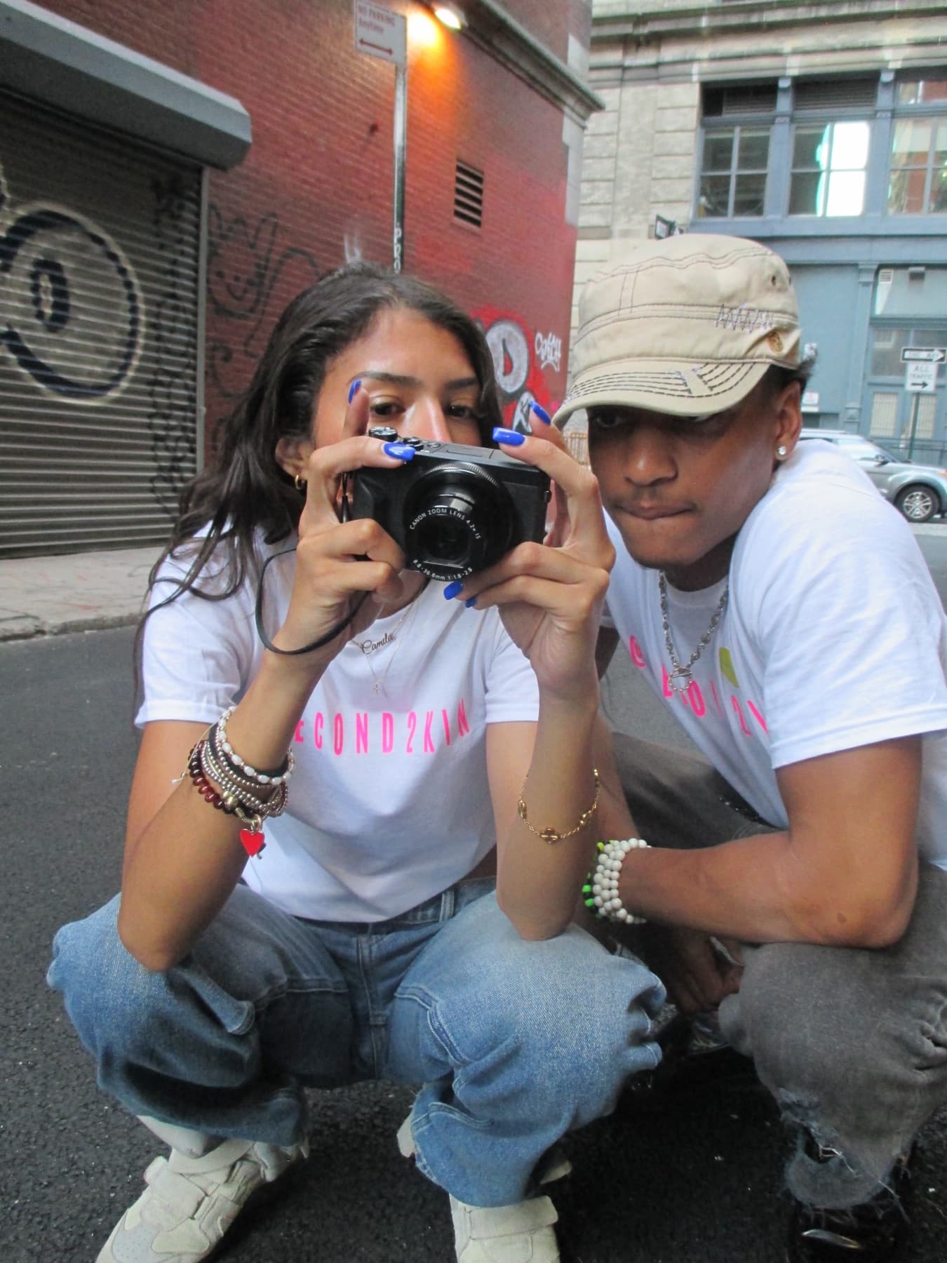 FaurY and a model crouched together over a camera, close angle