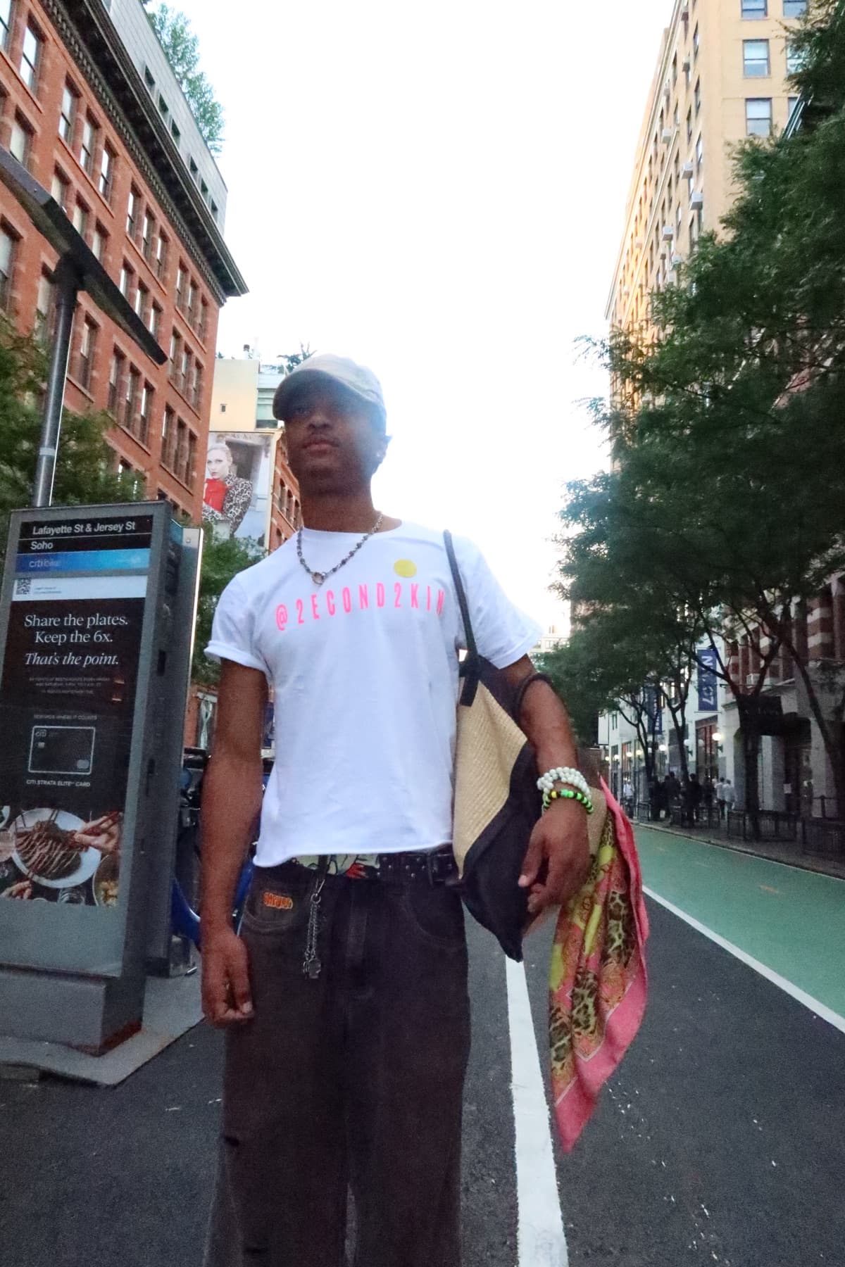 FaurY standing mid-street holding a bag