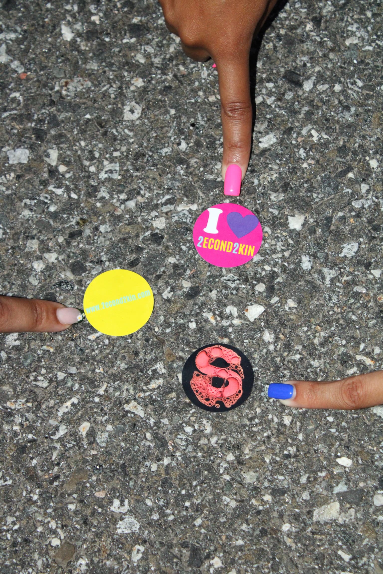 2econd2kin sticker sheet held over pavement
